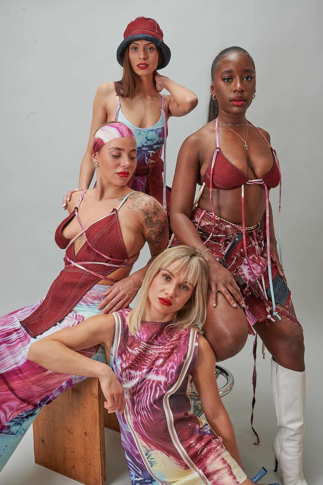 Model trägt handgenähtes Bachelor-Collection-Set: bordeauxfarbene Jeans-Konstruktion mit Kunstdruck-Bikini, Studioaufnahme